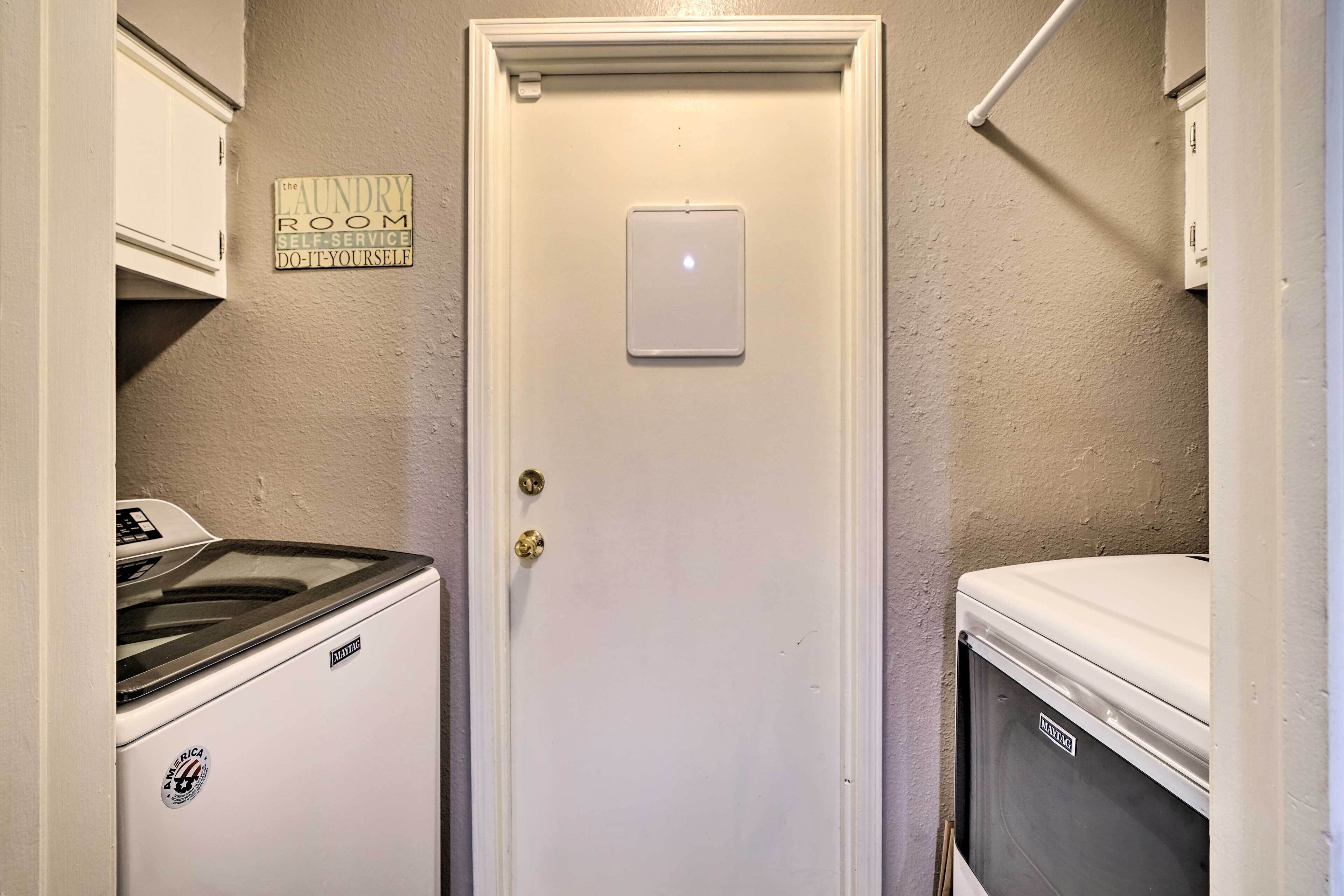 A laundry room with a white door, a Maytag washer, and a dryer.