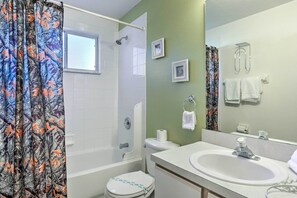 A bathroom with a bathtub, toilet, and sink.