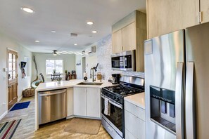 A modern kitchen with stainless steel appliances, wooden cabinets, and a central island. - Joshua Tree Getaway w/ Hot Tub, Pool & Fire Pit (Yucca Valley)