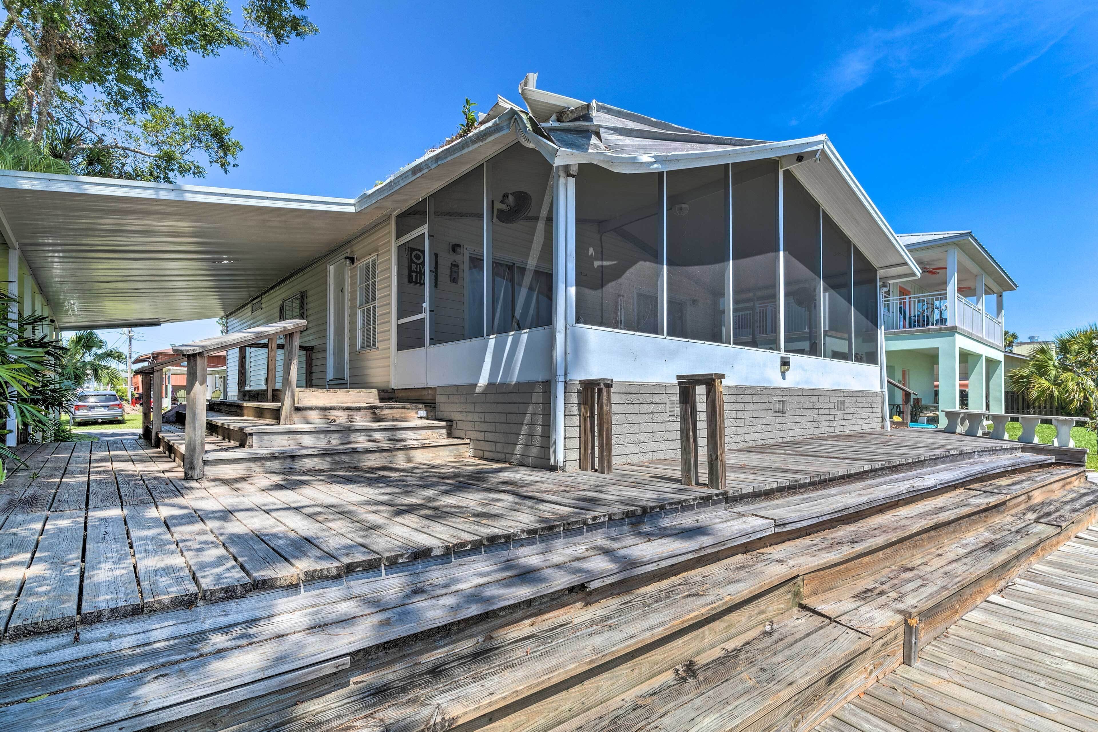 A house with a large porch, a covered deck, and a screened porch area.