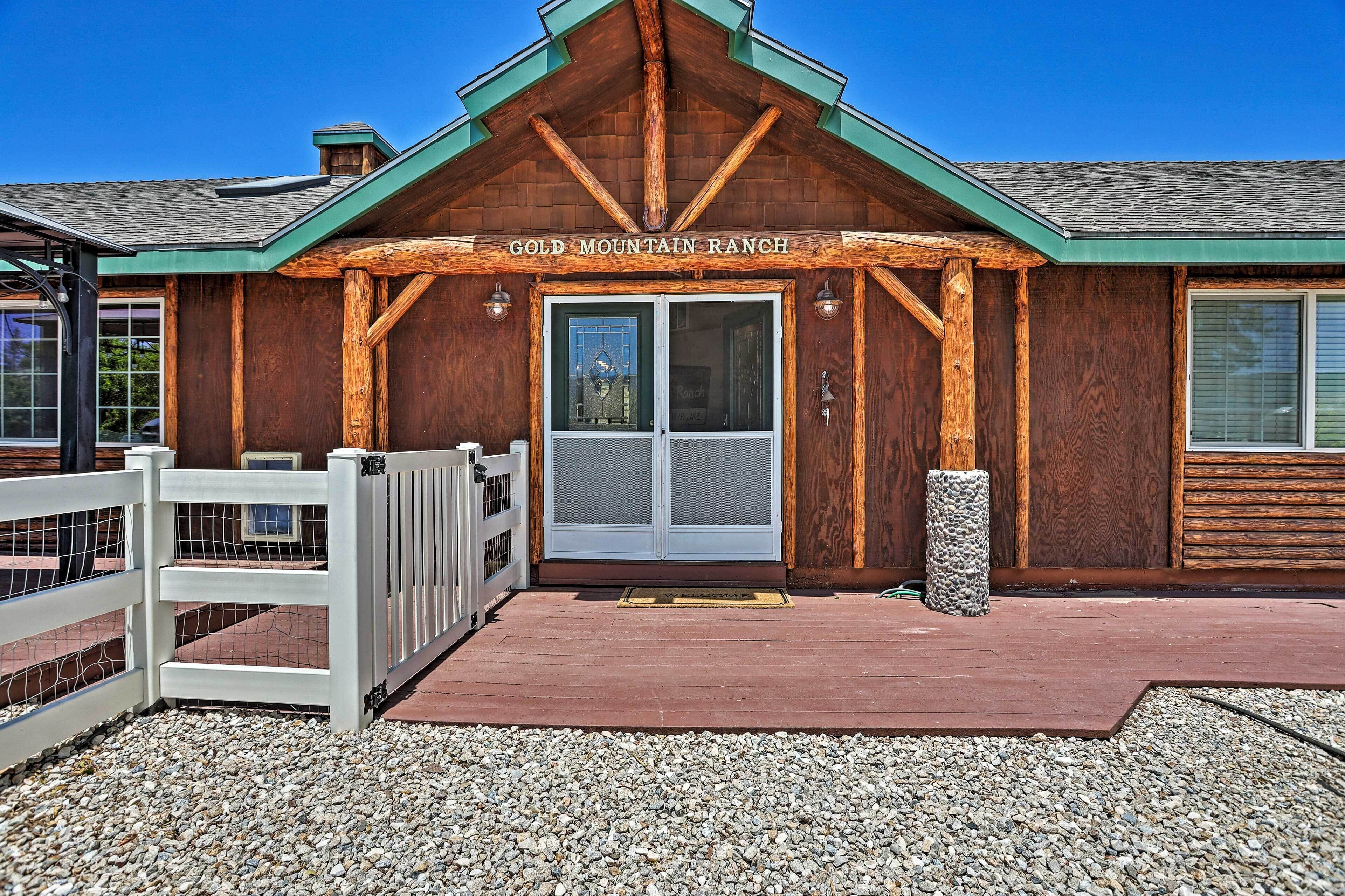 A rustic building with a wooden facade, a green roof, and a sign that reads 'GOLD MOUNTAIN RANCH'.