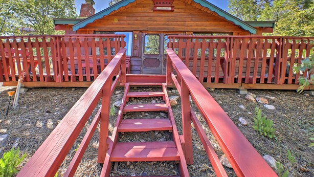 A wooden cabin with a red staircase leading to a door, surrounded by a red fence. - Big Bear Lake Cabin w/ Deck ~ 7 Mi to Ski Slopes! (Fawnskin)