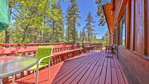 A wooden deck with red railings, a glass table, and a green chair. - Big Bear Lake Cabin w/ Deck ~ 7 Mi to Ski Slopes! (Fawnskin)