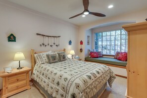 A bedroom with a bed, bedside tables, a window seat, and a ceiling fan. - Luxe Lake Arrowhead Home w/ Deck, 3 Mi to Village! (Lake Arrowhead)