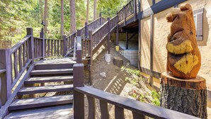 A wooden staircase leading up to a building with a bear sculpture on a tree stump. - Luxe Lake Arrowhead Home w/ Deck, 3 Mi to Village! (Lake Arrowhead)