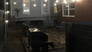 A backyard with a barbecue grill, outdoor furniture, and string lights. - IslandSeabreeze-Steps to Beach+1 Night Stays+Great for Cruisers/Families/Couples (Galveston)