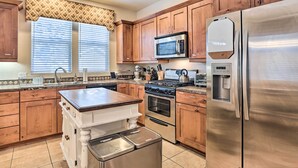 A kitchen with wooden cabinets, stainless steel appliances, a microwave, a stove, and a refrigerator. - 5 Mi to Big Bear Lake: Cozy Cottage w/ Hot Tub (Big Bear City)