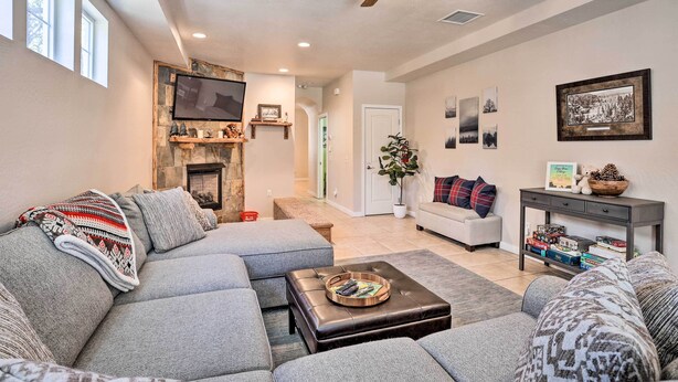 A modern living room with a sectional sofa, a coffee table, and a fireplace. - 5 Mi to Big Bear Lake: Cozy Cottage w/ Hot Tub (Big Bear City)