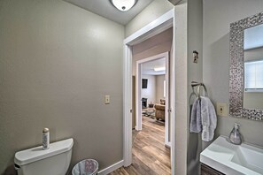 A bathroom with a toilet, sink, and mirror. There is a towel hanging on the wall. - Red Lodge Retreat w/ Yard - Walk to Restaurants! (Red Lodge)