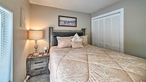 A bedroom with a bed, a nightstand, a lamp, a framed picture on the wall, and a closet. - Red Lodge Retreat w/ Yard - Walk to Restaurants! (Red Lodge)