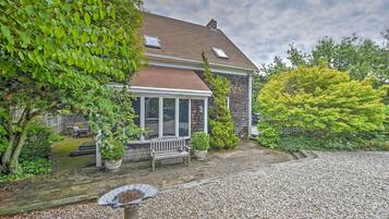Enjoy a peaceful retreat in this two-story house surrounded by a lush garden and a backyard with a wooden deck.