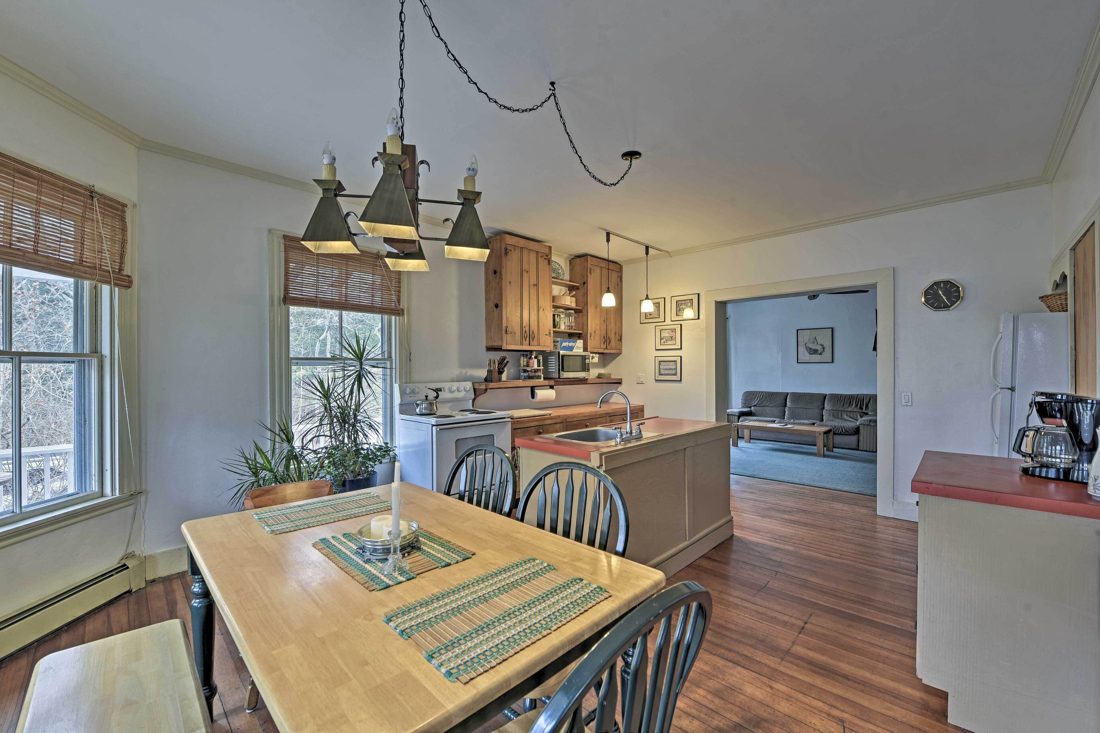 A spacious kitchen with wooden cabinets, a central island, and pendant lighting.