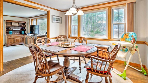 A dining room with a round table, wooden chairs, and a high ceiling with a chandelier. - 2 Mi to Shore: Home w/ BBQ & Beach Gear in Mashpee (Mashpee)