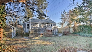 A two-story house with a front porch, a garage, and a fenced backyard. - Steps to Cape Cod Canal: Pet-friendly Home (Buzzards Bay)