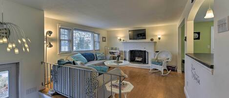 A cozy living room with a fireplace, a sofa, and a dining area.