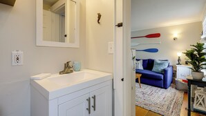 A bathroom with a white sink, a mirror, and a towel rack. - 1 Mi to Ferry: 'sea Street Cottage' in Hyannis (Hyannis)