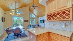 A spacious kitchen with wooden cabinets, a granite countertop, and a ceiling fan. - Central Townhome < 1 Mi to The Village at Mammoth! (Mammoth Lakes)