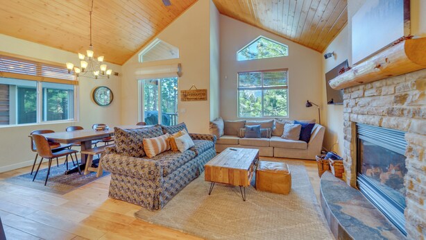 A spacious living room with a high ceiling, a fireplace, and a dining area. - Central Townhome < 1 Mi to The Village at Mammoth! (Mammoth Lakes)