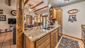 A kitchen with a granite countertop, wooden cabinets, and a ceiling fan. - Comfy 'aspen Ridge' Home ~ 3 Mi to Ski Lifts (Cloudcroft)