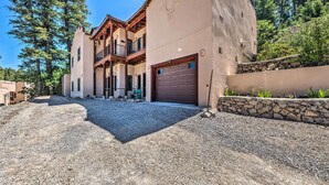 A multi-story building with a stone facade, a garage, and a balcony. - Comfy 'aspen Ridge' Home ~ 3 Mi to Ski Lifts (Cloudcroft)