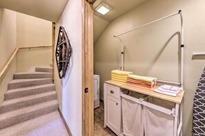 A laundry area with a washing machine, a drying rack, and a small cabinet. - Cozy Ruidoso Cabin Retreat w/ Private Hot Tub (Ruidoso)