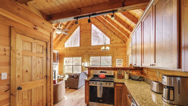 A wooden cabin kitchen with a stove, oven, and granite countertop. - Elevated Cabin Bordering Smoky Mountain Nat'l Park (Bryson City)