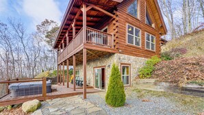 A two-story log cabin with a stone foundation, a wooden deck, and a covered porch. - Elevated Cabin Bordering Smoky Mountain Nat'l Park (Bryson City)