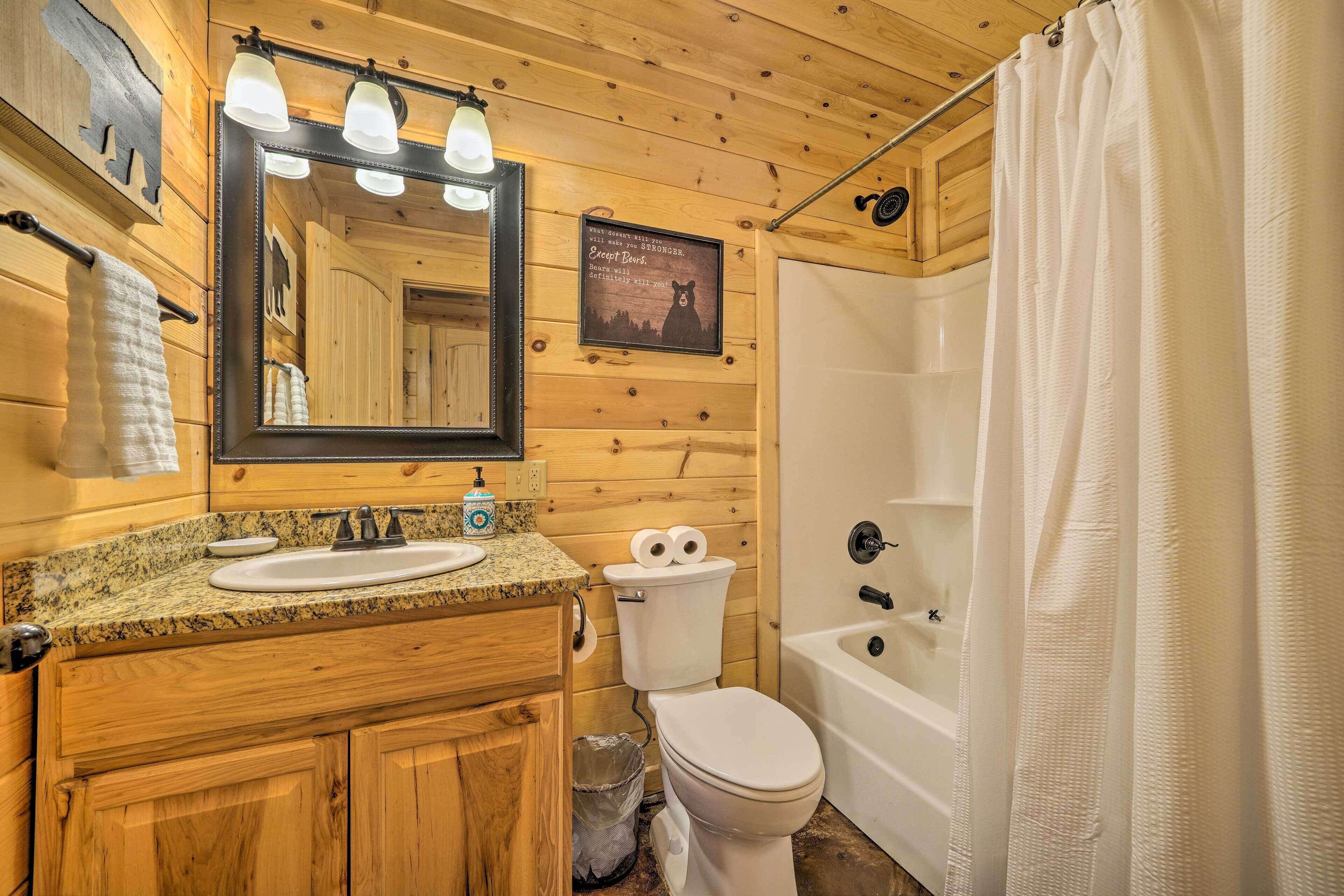 A wooden cabin bathroom with a sink, toilet, and bathtub.