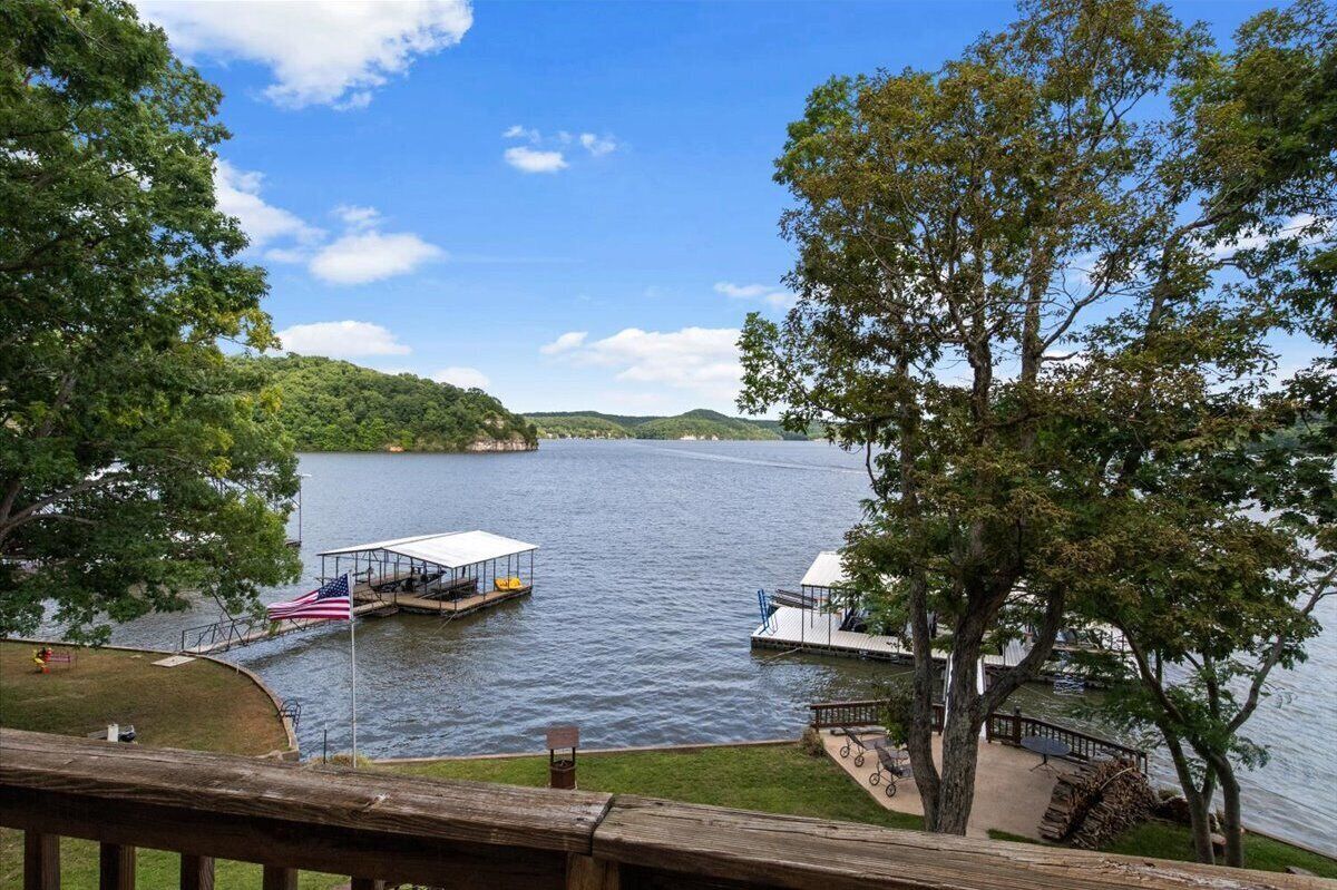 A lake with docked boats, a flag, and a grassy area with a wooden deck.