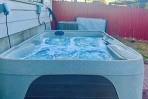 Ett bubbelbad med inbyggd sittplats och en kontrollpanel, anslutet till en extern strömkälla.