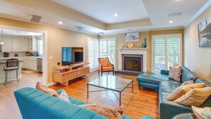 A spacious living area with a sofa, a glass coffee table, and a television. There is a kitchen area with cabinets and a dining table. - Pool, Hot Tub & Outdoor Theater: Franklin Retreat (Franklin)