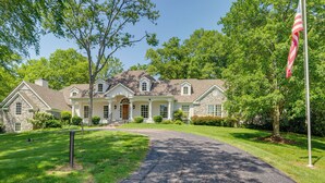 A large, two-story house with a stone facade, a front porch, and a flagpole. - Pool, Hot Tub & Outdoor Theater: Franklin Retreat (Franklin)