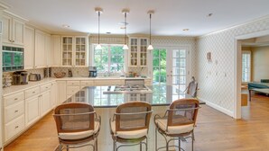 A spacious kitchen with a large island, white cabinetry, and pendant lighting. - Pool, Hot Tub & Outdoor Theater: Franklin Retreat (Franklin)