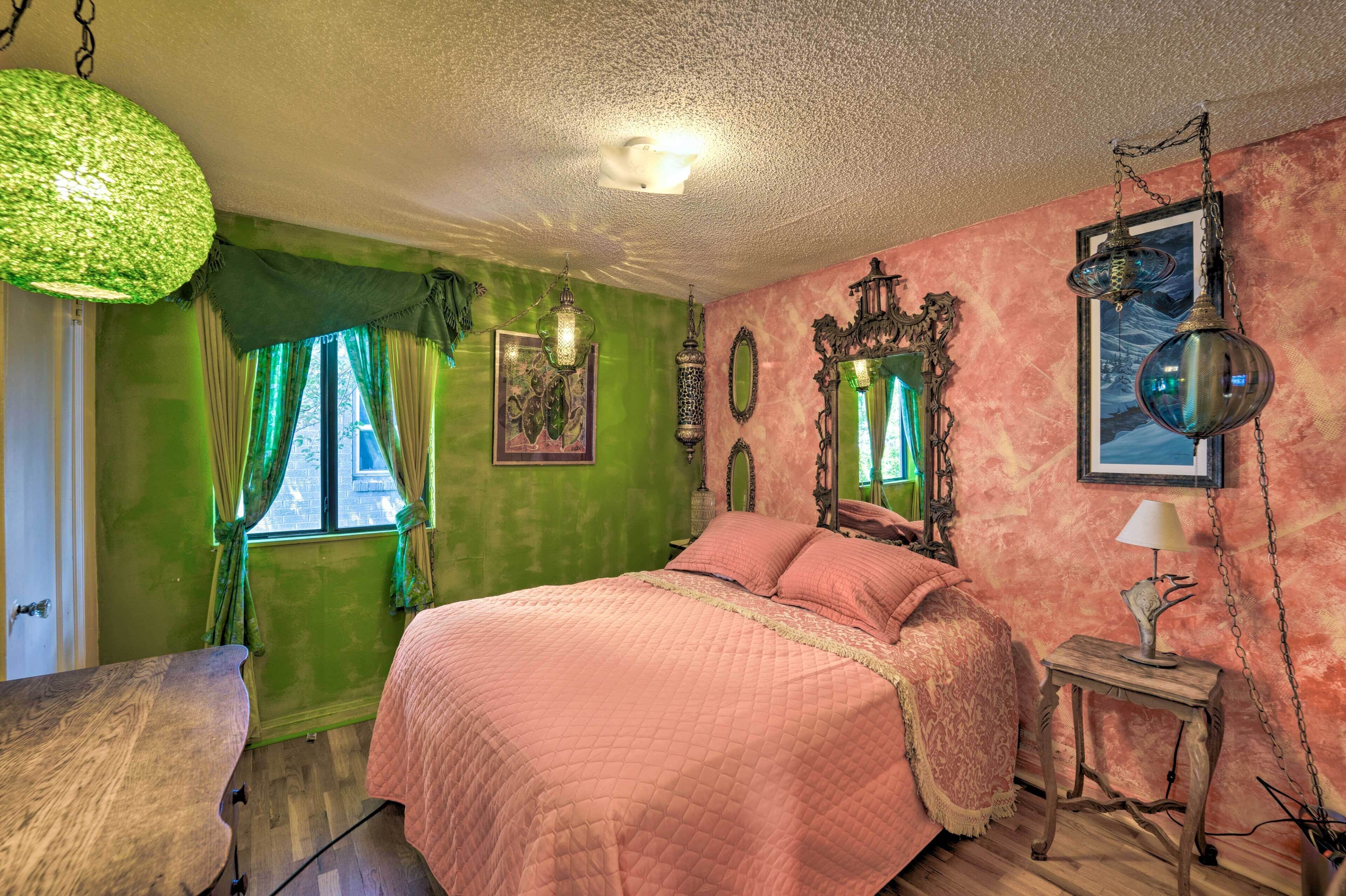 A room with a bed, a wooden table, and a lamp.