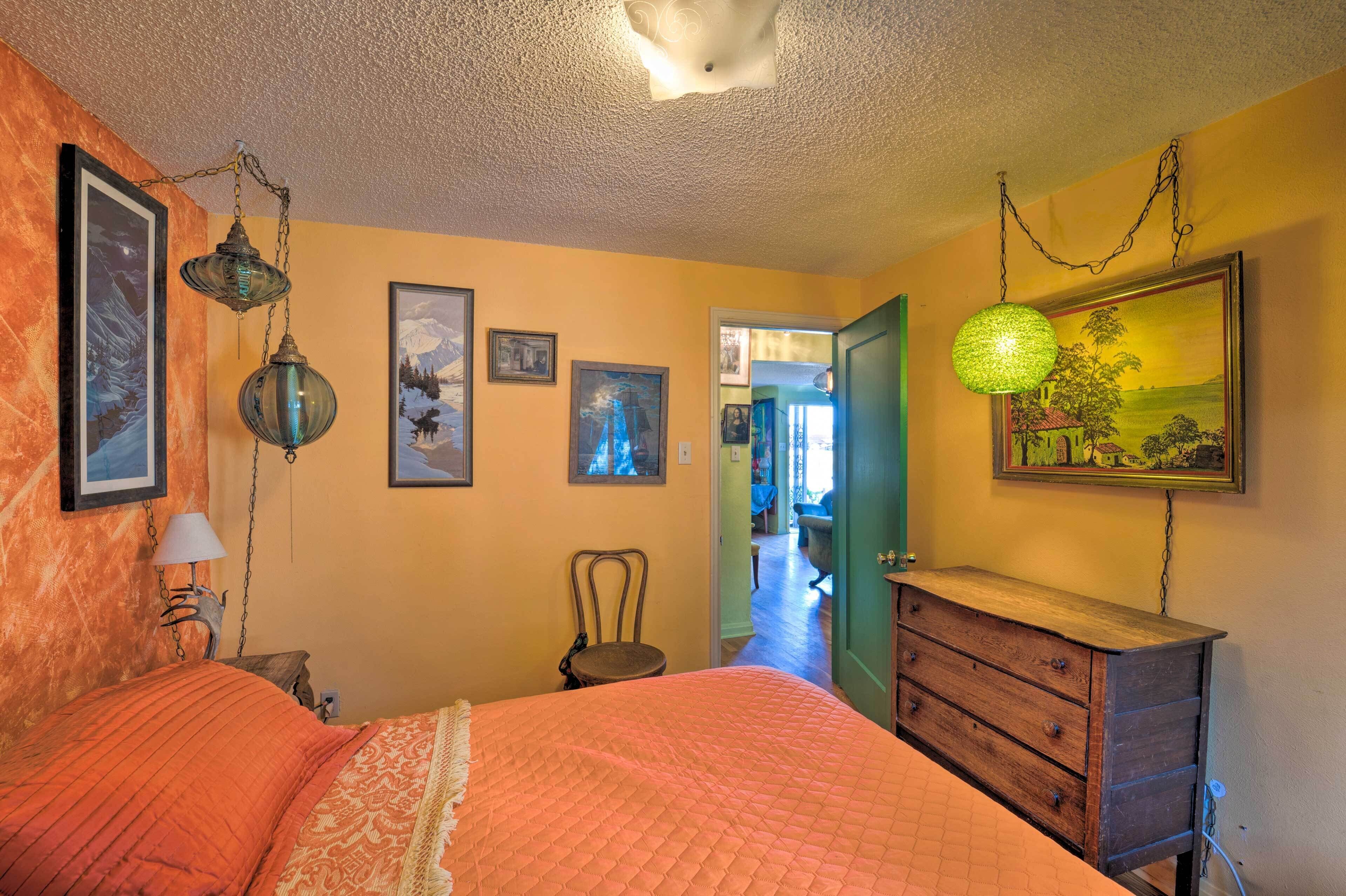 Un dormitorio con cama, cómoda y lámparas fijadas a la pared.
