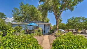 A house with a covered porch, a pathway leading to the entrance, and surrounding greenery. - Walk to Olde Town Arvada - 1940 Vintage Bungalow! (Arvada)