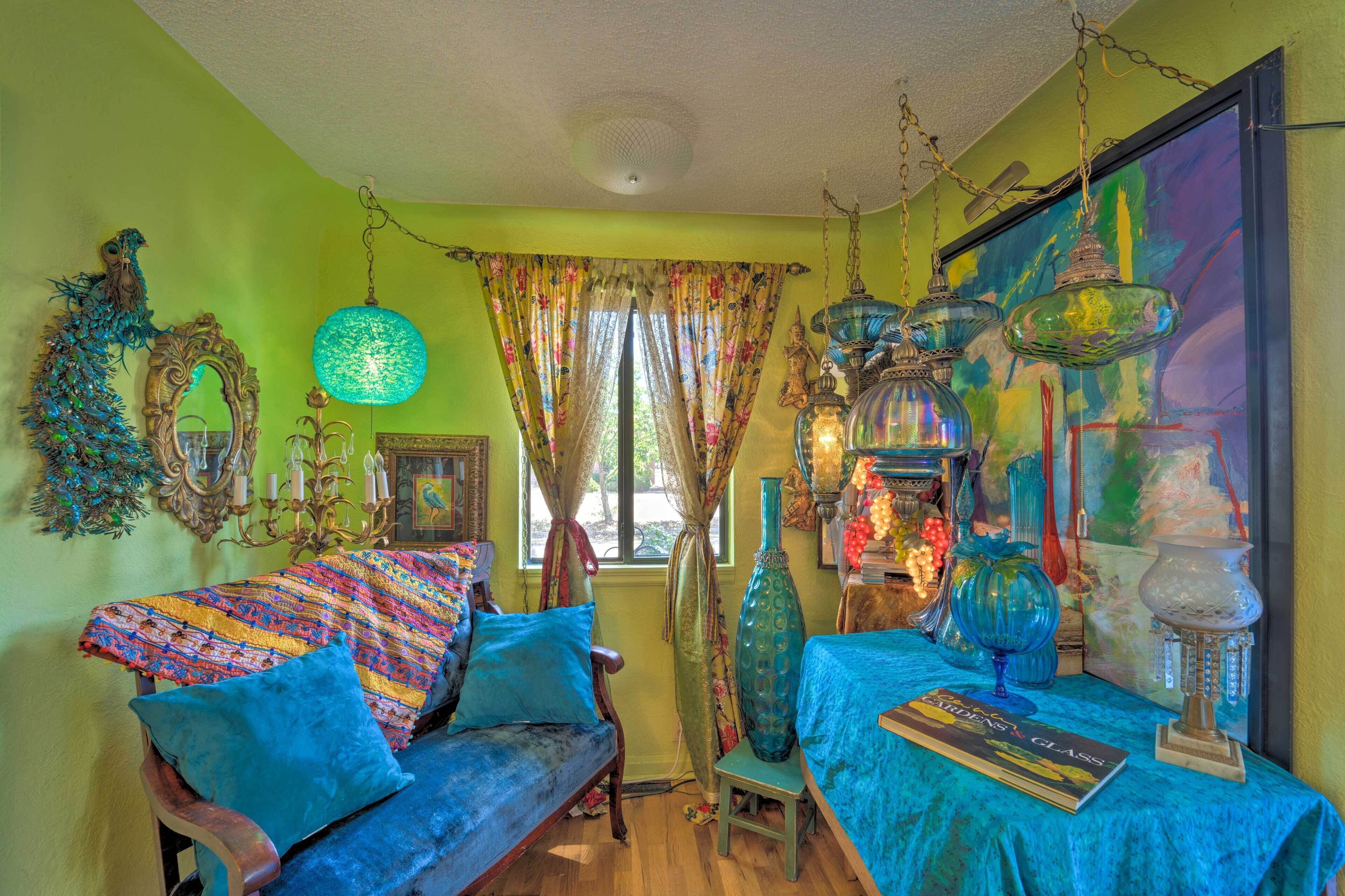 A cozy room with a blue sofa, a table with a book, and decorative glassware.