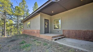 A modern house with a wooden deck, a front door, and a window.