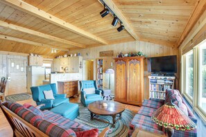 A cozy cabin interior with a living room, sofa, armchair, and a television. - Cozy Baileys Harbor Cottage on Lake Michigan! (Baileys Harbor)