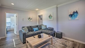 A modern living room with a sectional sofa, a coffee table, and artwork on the walls.