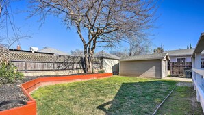 A backyard with a wooden fence, a tree, and a shed.