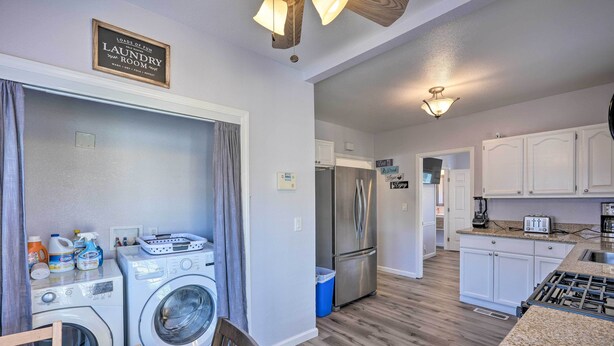 A laundry room with a washing machine and dryer, a dining area with a table and chairs, and a kitchen with a refrigerator and stove.