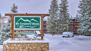 Une enseigne pour « Hi Country Haus », avec un logo représentant des montagnes, indiquant qu’il s’agit d’un centre de villégiature situé en montagne.
