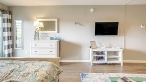 A bedroom with a bed, a dresser, a TV, and a small table with decorative items. - Steps to Boardwalk! Couples Retreat in Ocean City (Ocean City)