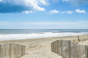 A beach with wooden fences and a clear sky.