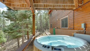 A hot tub on a wooden deck with a view of a forest. - Angel Fire Rental Cabin w/ Hot Tub & Mountain View (Angel Fire)