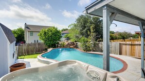 A backyard with a swimming pool and hot tub, surrounded by a wooden fence and trees. - San Antonio Home w/ Private Hot Tub + Pool! (San Antonio)