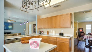 A modern kitchen with wooden cabinets, a central island, and pendant lighting. - San Antonio Home w/ Private Hot Tub + Pool! (San Antonio)