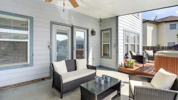 A covered patio with wicker furniture, a glass coffee table, and a ceiling fan. - San Antonio Home w/ Private Hot Tub + Pool! (San Antonio)