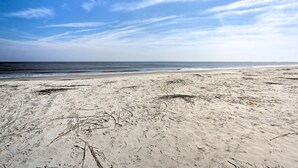 En strand med klare himmel og roligt vand.